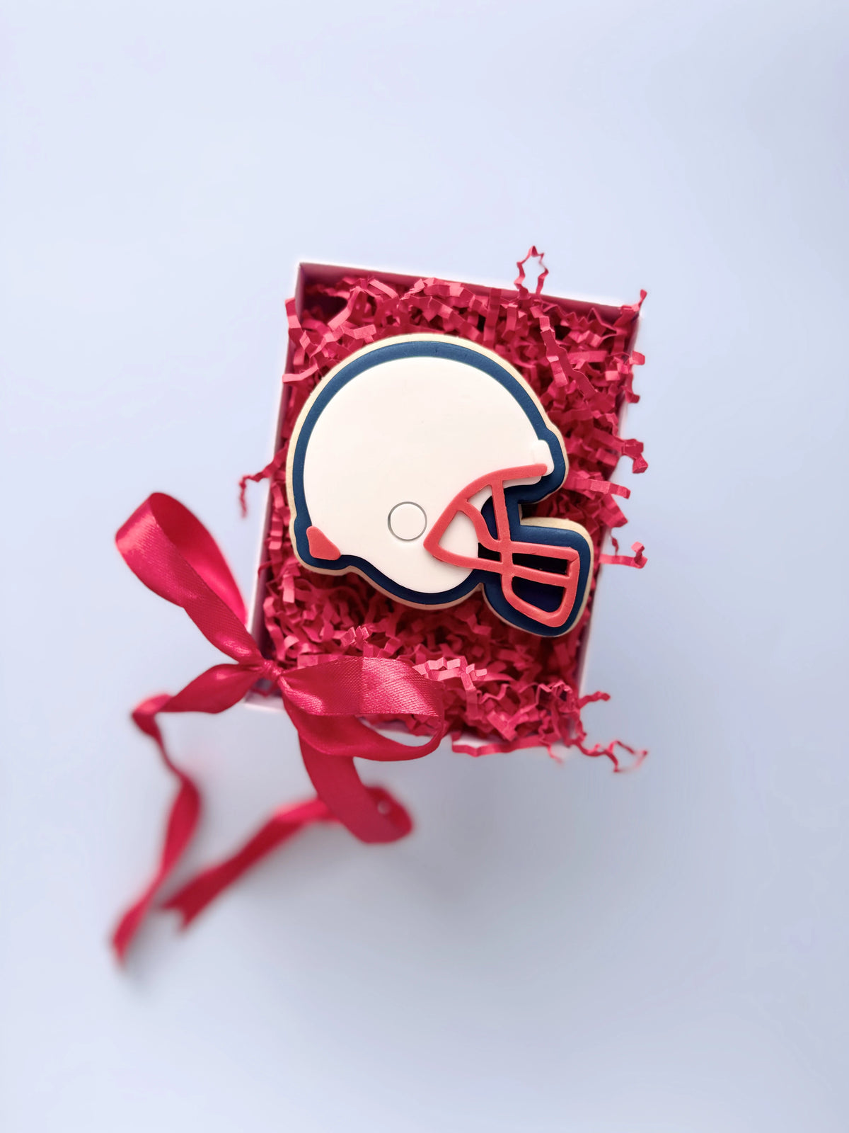 Dekorierter Keks als Football-Helm in Weiss, Dunkelblau und Rot. Motivbeispiel von Danis Drip.